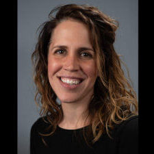 Woman smiling with shoulder length curly hair