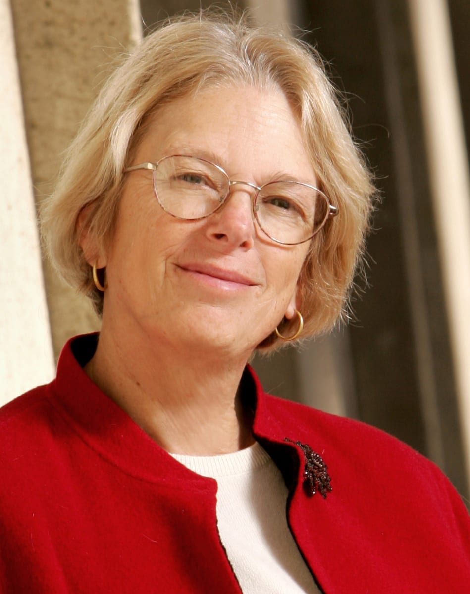 Woman with short blonde hair and wearing wire rimmed glasses.
