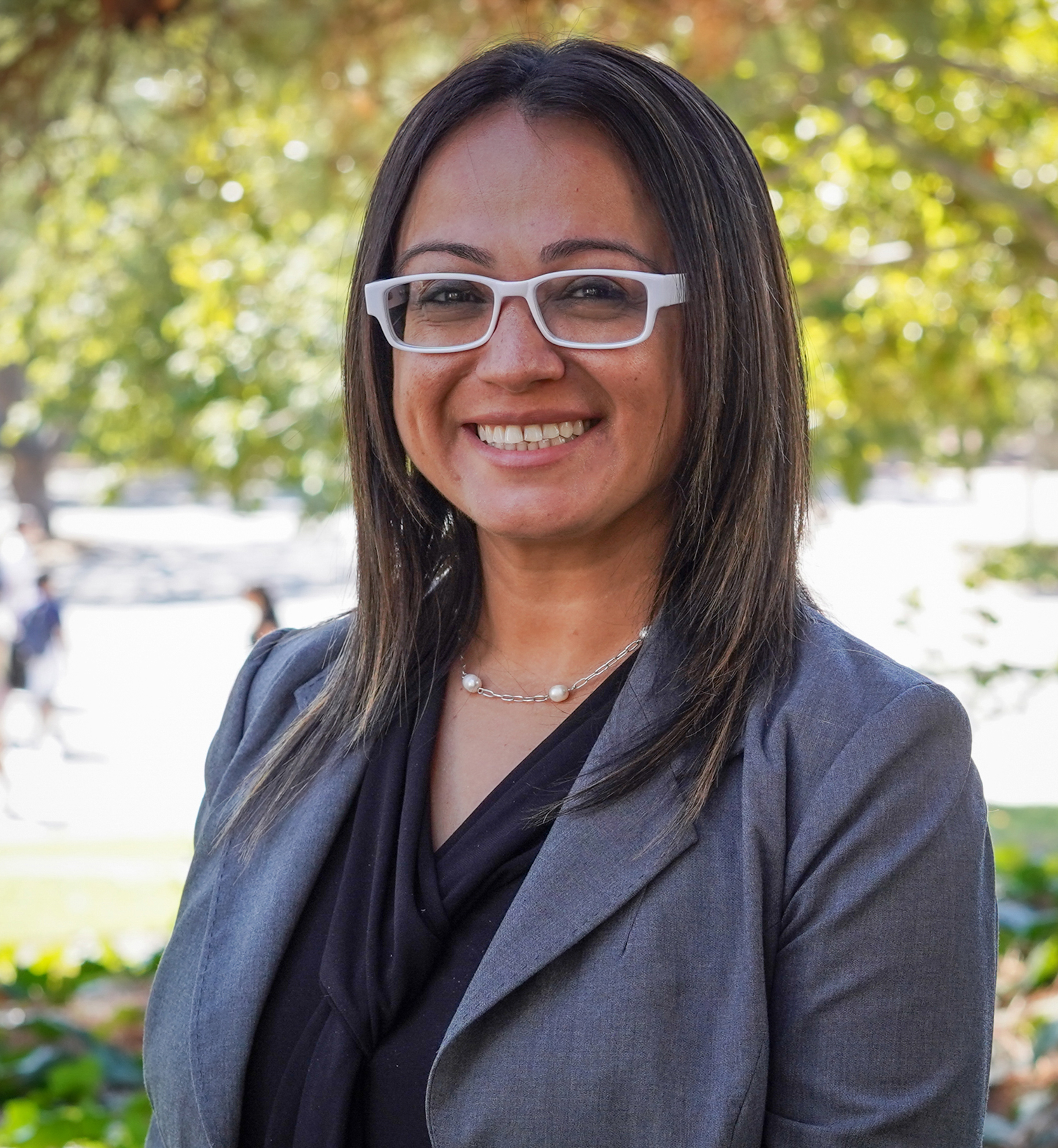 Woman with white glasses and long dark hair.
